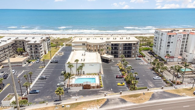 drone / aerial view featuring a water view and a view of the beach