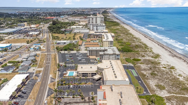 drone / aerial view featuring a city view, a water view, and a beach view