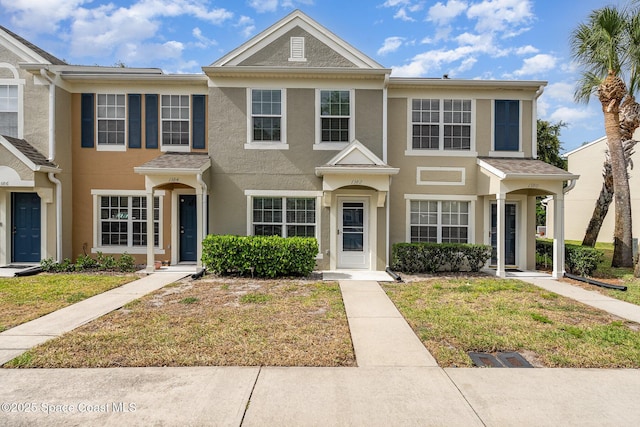 view of property featuring a front yard and stucco siding
