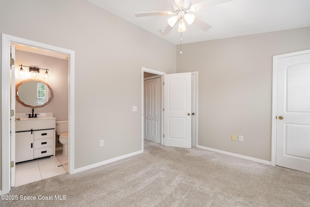 unfurnished bedroom featuring baseboards, ensuite bathroom, light carpet, and high vaulted ceiling