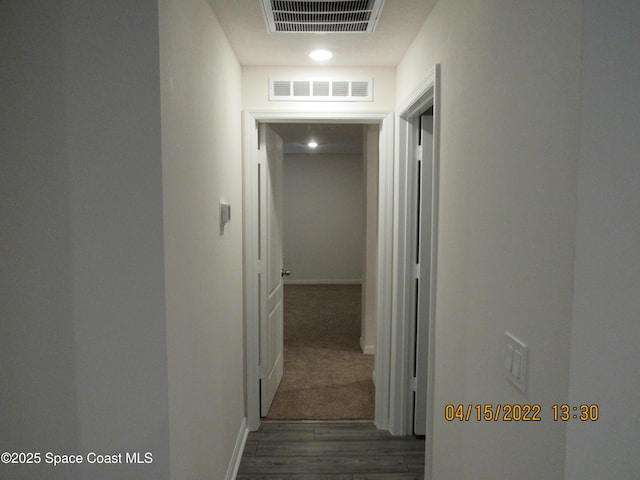 corridor featuring baseboards, visible vents, and wood finished floors