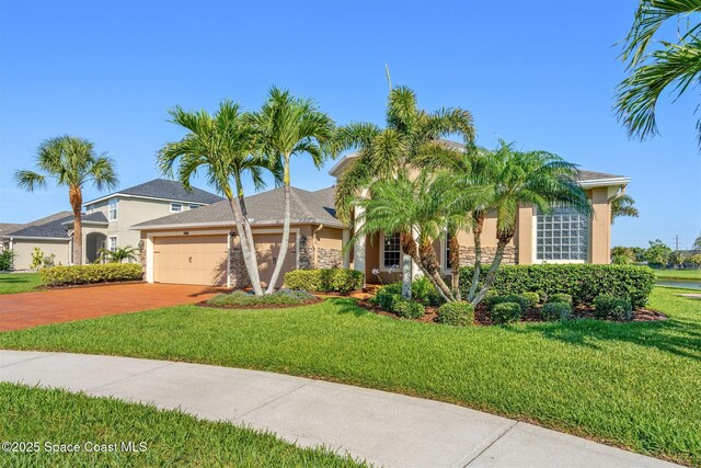 5770 Mascaro Ct, Melbourne, FL 32940 - view of front of home featuring stucco siding, a garage, a front lawn, and driveway