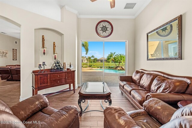 5770 Mascaro Ct, Melbourne, FL 32940 - living area featuring ceiling fan, wood finished floors, crown molding, arched walkways, and baseboards
