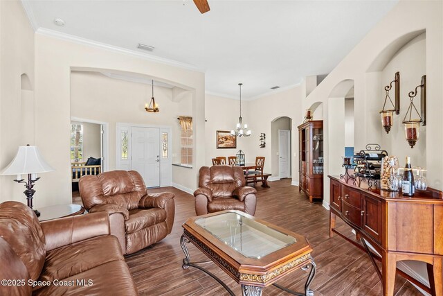 5770 Mascaro Ct, Melbourne, FL 32940 - living area featuring arched walkways, dark wood-style flooring, a chandelier, baseboards, and ornamental molding
