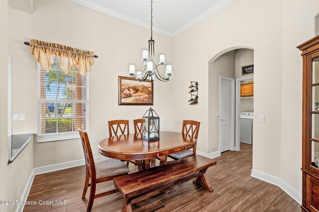 5770 Mascaro Ct, Melbourne, FL 32940 - dining area with washer / dryer, arched walkways, wood finished floors, crown molding, and a chandelier