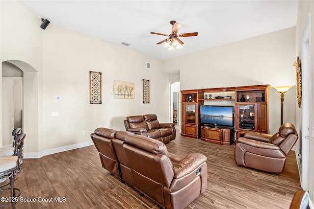 5770 Mascaro Ct, Melbourne, FL 32940 - living area with arched walkways, ceiling fan, wood finished floors, and baseboards