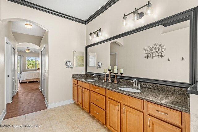 5770 Mascaro Ct, Melbourne, FL 32940 - ensuite bathroom featuring double vanity, ornamental molding, baseboards, and ceiling fan