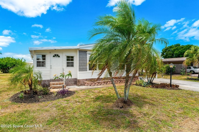 manufactured / mobile home featuring entry steps and a front lawn