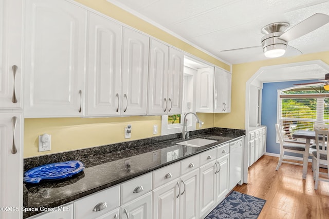 kitchen with a ceiling fan, a sink, light wood-type flooring, white cabinetry, and white dishwasher