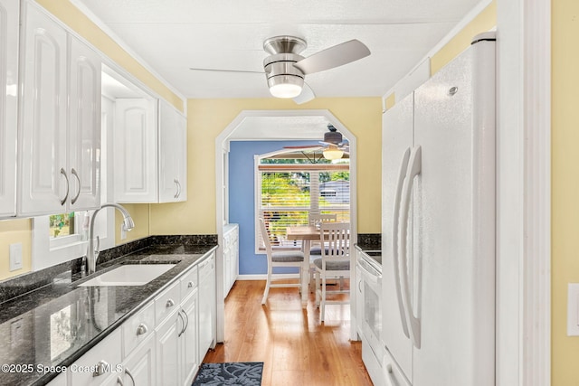 kitchen featuring a ceiling fan, white appliances, white cabinets, and a sink