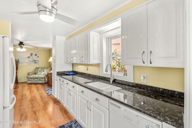 kitchen featuring a sink, white appliances, ceiling fan, light wood-style flooring, and white cabinetry