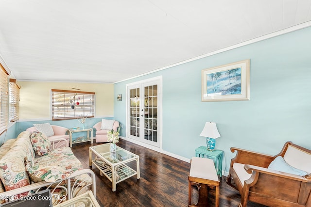living area with crown molding, wood finished floors, and baseboards