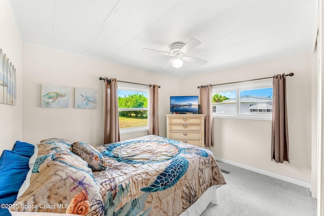 carpeted bedroom with baseboards, multiple windows, and a ceiling fan
