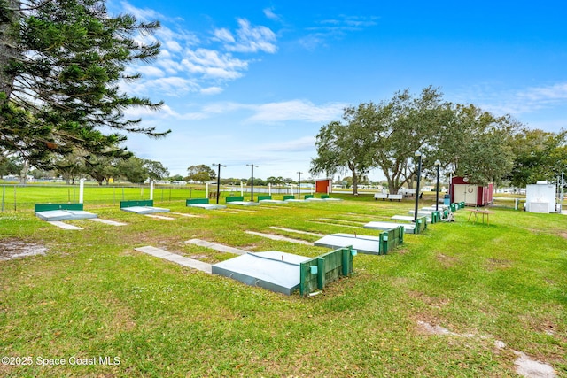 view of property's community featuring a yard and fence