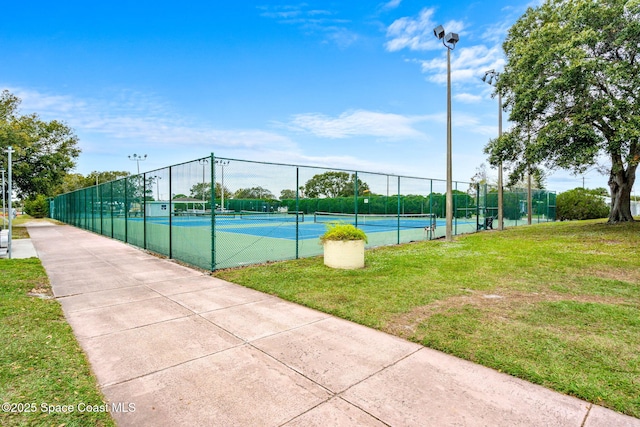 view of sport court with a yard and fence