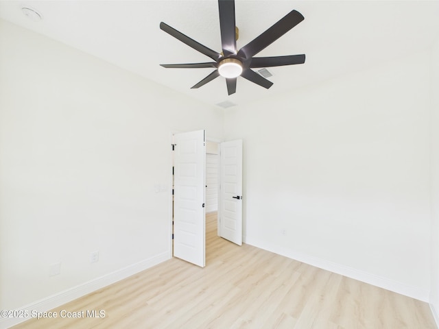 spare room featuring wood finished floors, baseboards, and ceiling fan