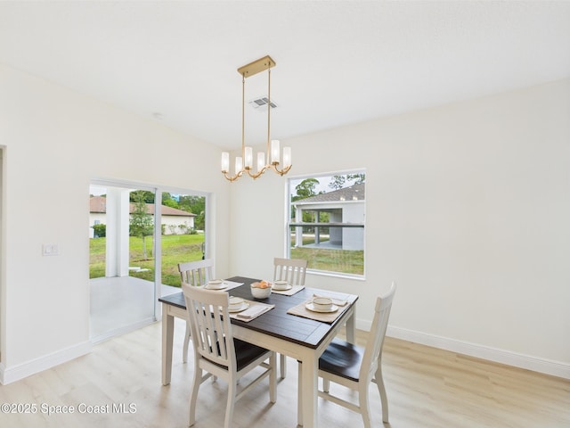 dining area featuring an inviting chandelier, visible vents, plenty of natural light, and light wood-style floors
