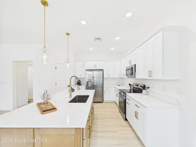 kitchen featuring a sink, stainless steel appliances, a center island with sink, recessed lighting, and light wood-style flooring