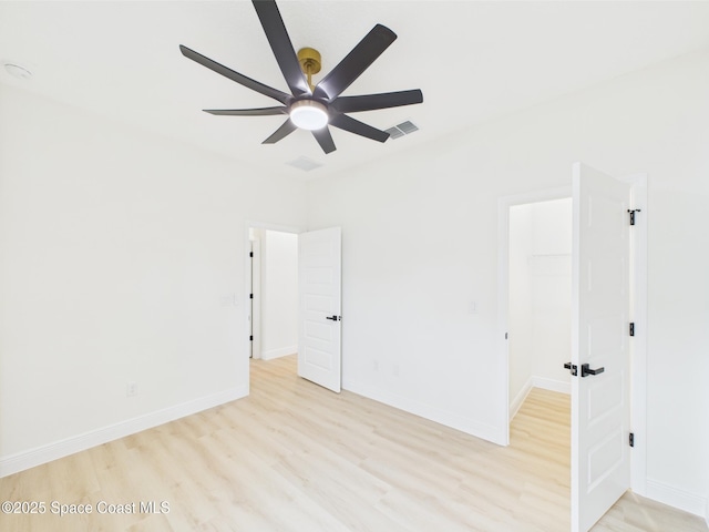 spare room with ceiling fan, baseboards, visible vents, and light wood-style floors
