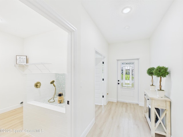 entrance foyer with baseboards and light wood-style floors