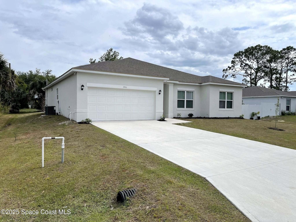 ranch-style house featuring central air condition unit, an attached garage, stucco siding, and driveway