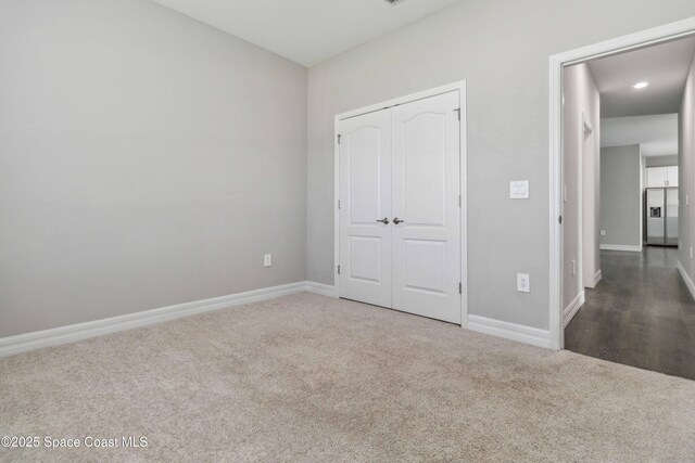 780 Geddes St SW, Palm Bay, FL 32908 - unfurnished bedroom with carpet, baseboards, a closet, stainless steel fridge, and recessed lighting