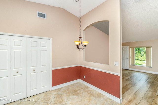 766 Preakness Dr, Melbourne, FL 32904 - unfurnished dining area with lofted ceiling, baseboards, an inviting chandelier, visible vents, and arched walkways
