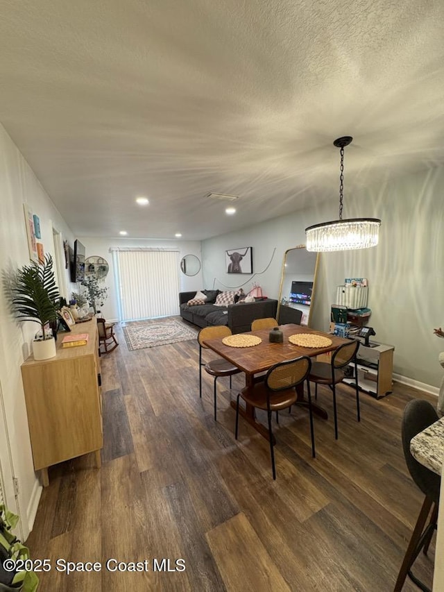 dining room with a textured ceiling, dark wood finished floors, baseboards, and recessed lighting