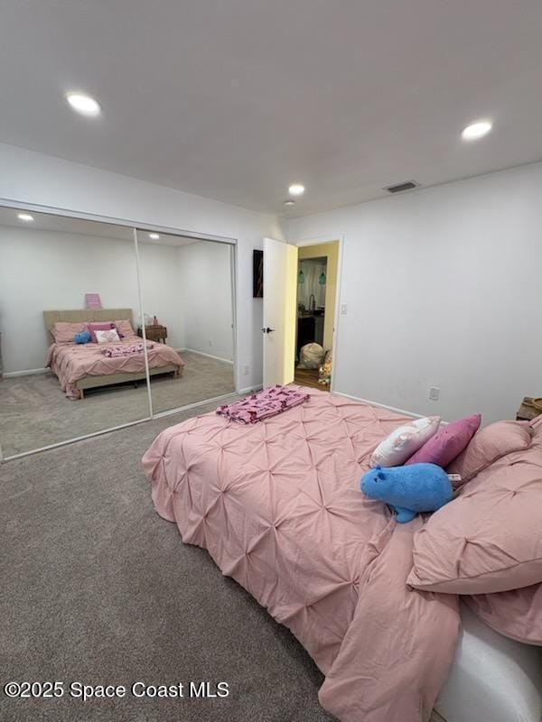 carpeted bedroom with a closet, visible vents, and recessed lighting
