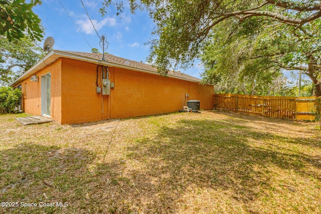 rear view of property featuring cooling unit and stucco siding