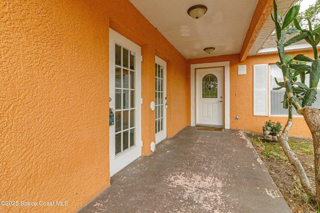 view of exterior entry featuring stucco siding