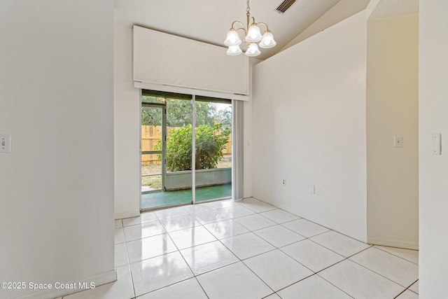 empty room featuring a chandelier, lofted ceiling, and light tile patterned flooring