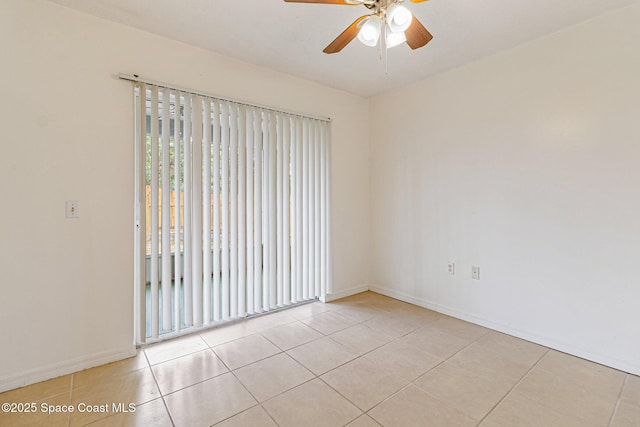unfurnished room with ceiling fan, light tile patterned floors, and baseboards