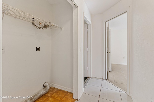 clothes washing area featuring electric dryer hookup and baseboards