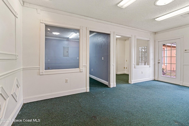 unfurnished room featuring dark colored carpet, a textured ceiling, and baseboards