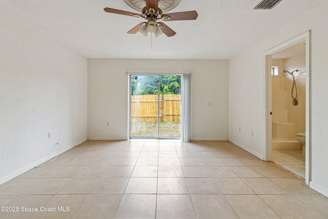 empty room featuring a ceiling fan, light tile patterned flooring, and baseboards