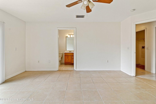 empty room featuring a ceiling fan, light tile patterned floors, baseboards, and a smoke detector