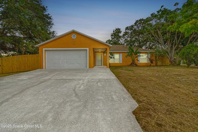 ranch-style home featuring driveway, an attached garage, and stucco siding