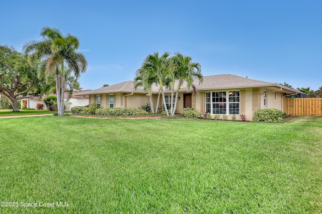 ranch-style home with fence, stucco siding, and a front yard