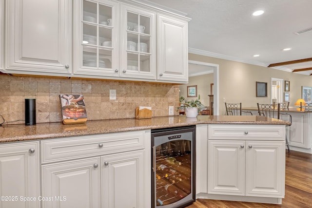 bar featuring backsplash, crown molding, visible vents, and wine cooler