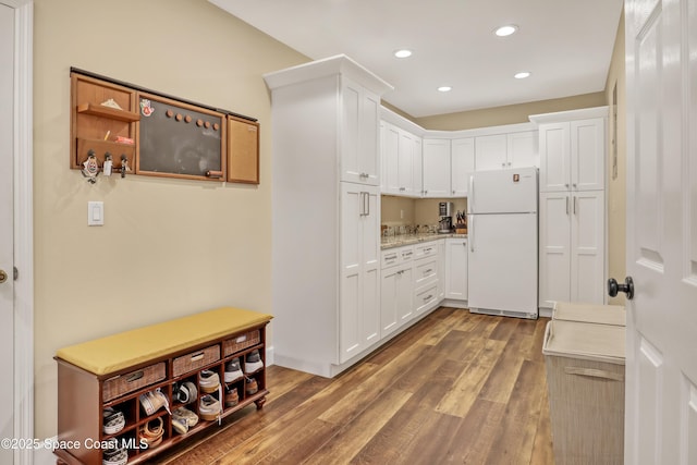 kitchen featuring freestanding refrigerator, wood finished floors, white cabinets, and recessed lighting