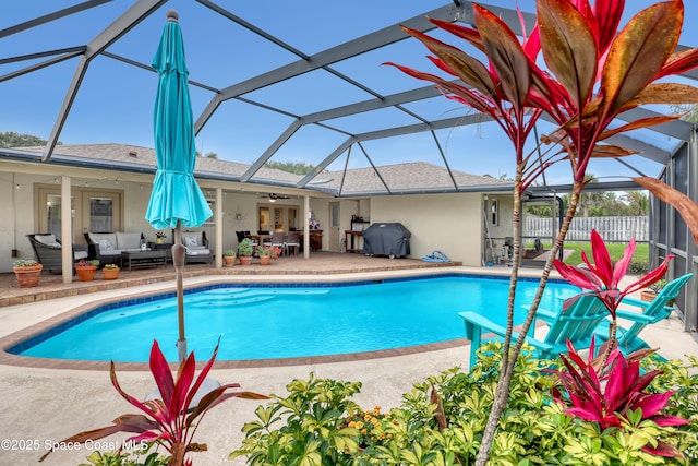 pool featuring glass enclosure, ceiling fan, an outdoor hangout area, and a patio area