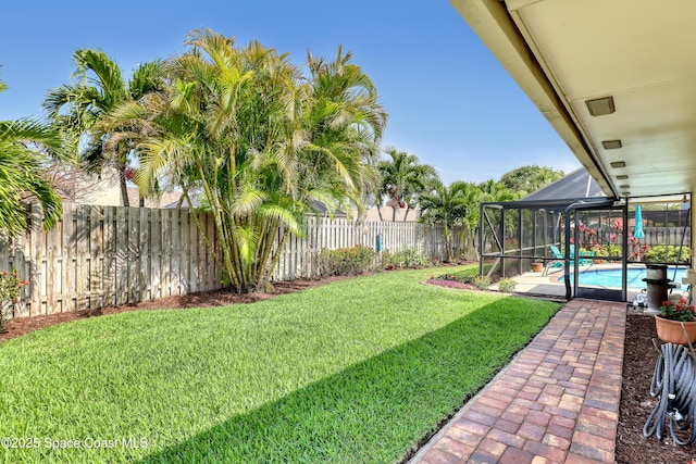 view of yard with a fenced in pool, a fenced backyard, and a lanai