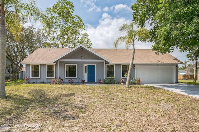 1680 Travis St SE, Palm Bay, FL 32909 - single story home with board and batten siding, driveway, an attached garage, a shingled roof, and a front yard