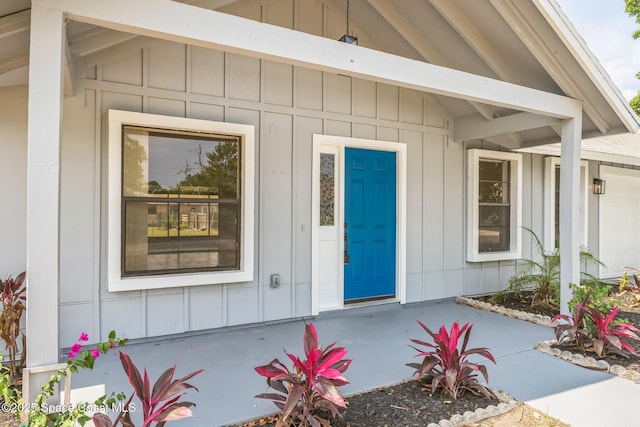 1680 Travis St SE, Palm Bay, FL 32909 - doorway to property with board and batten siding, an attached garage, and covered porch