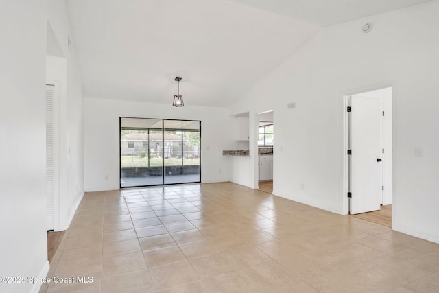 1680 Travis St SE, Palm Bay, FL 32909 - unfurnished room with light tile patterned flooring, high vaulted ceiling, baseboards, and a smoke detector