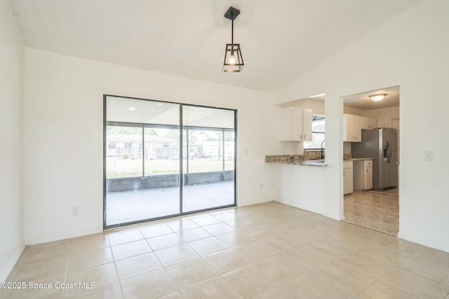 1680 Travis St SE, Palm Bay, FL 32909 - unfurnished dining area with lofted ceiling, light tile patterned flooring, and baseboards