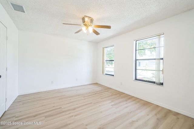 1680 Travis St SE, Palm Bay, FL 32909 - spare room featuring a textured ceiling, light wood-type flooring, ceiling fan, and baseboards
