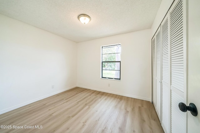 1680 Travis St SE, Palm Bay, FL 32909 - unfurnished bedroom featuring a closet, light wood finished floors, a textured ceiling, and baseboards