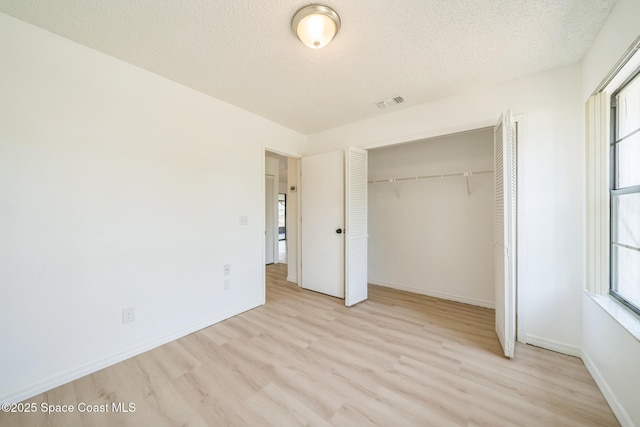 1680 Travis St SE, Palm Bay, FL 32909 - unfurnished bedroom with multiple windows, wood finished floors, a textured ceiling, and a closet